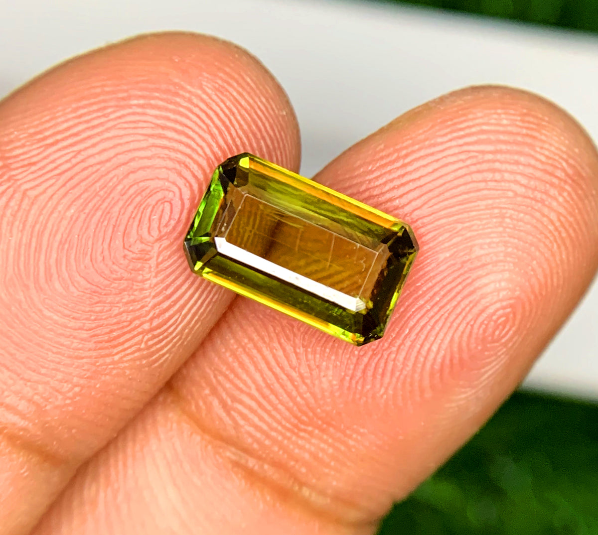 Green sphene gemstone, step facet view
Natural emerald cut sphene, angled view
2.35 carat green sphene, full view