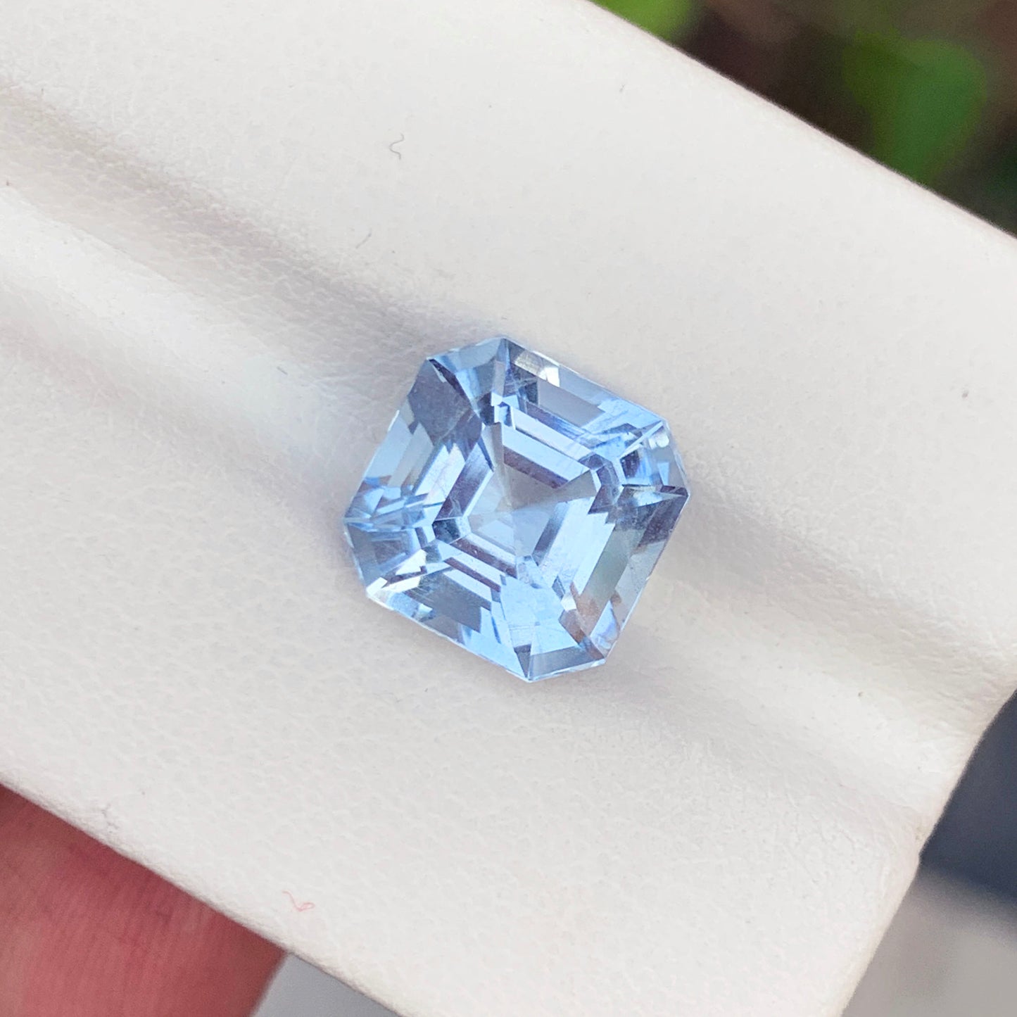Aquamarine gemstone with scale reference for size
Asscher cut faceted crown detail on aquamarine
