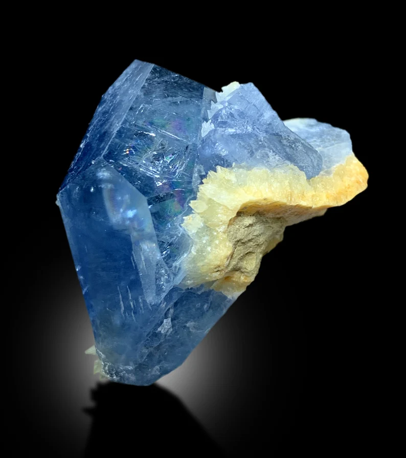 Celestine crystal dimensions 33 by 28 by 24 mm
Tabular celestine crystal back angle view
Deep blue color detail on celestine crystal
Raw celestine crystal on yellow calcite matrix