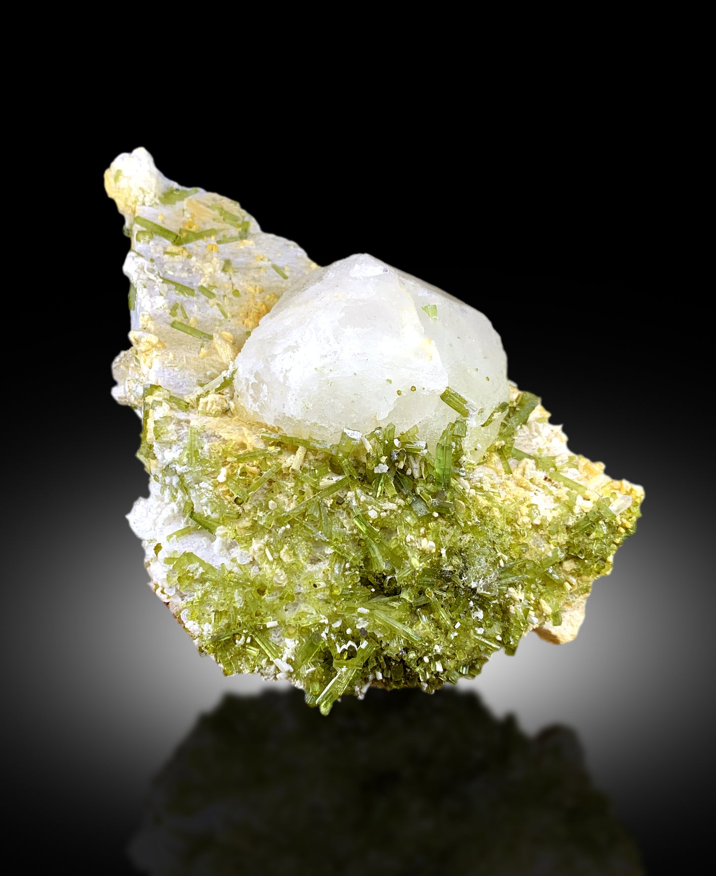 Closeup of green tourmaline crystal luster and color
Tourmaline cluster side view showing pollucite crystal