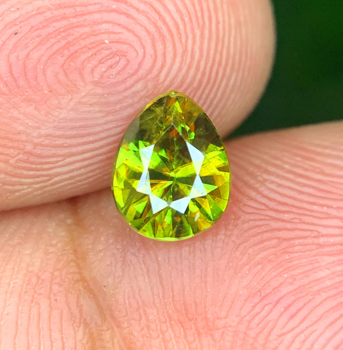 Pear cut sphene gemstone, front view
Green sphene showing natural fire, close-up