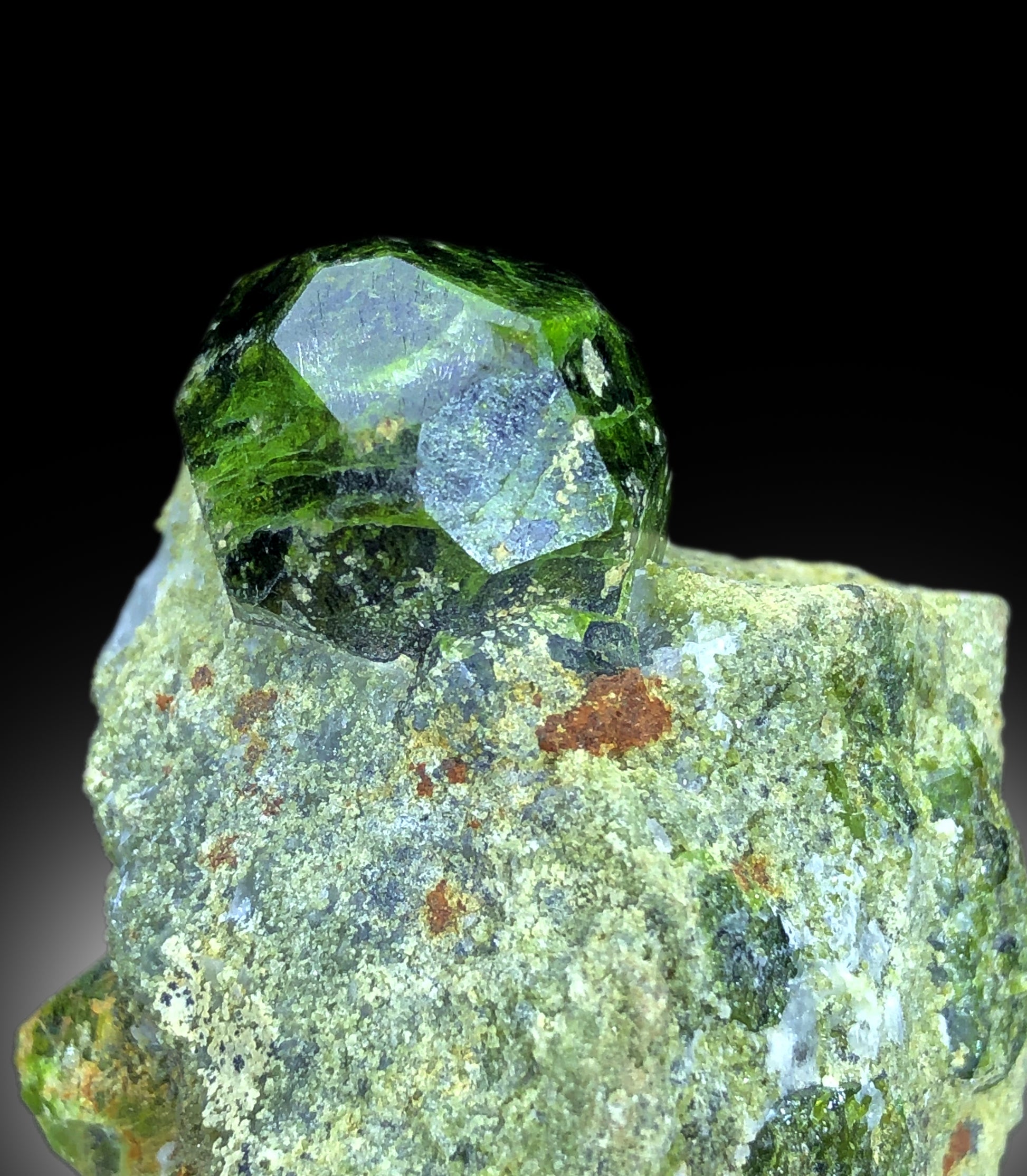 Lush green color detail on demantoid garnet crystal
Raw demantoid garnet crystal on natural matrix base