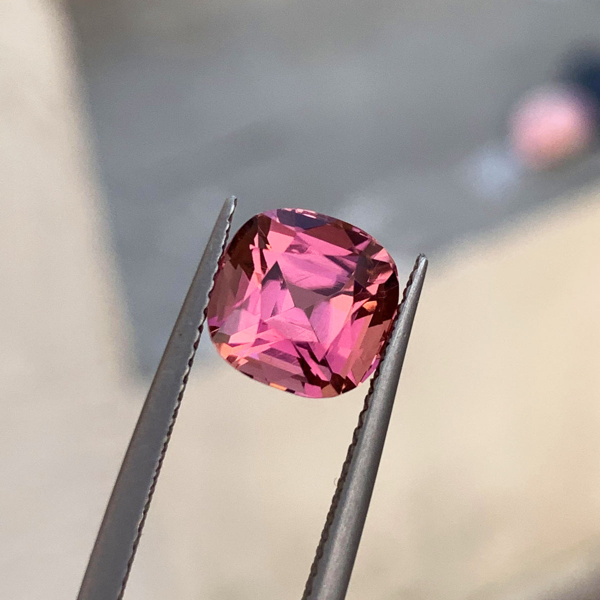 Deep cushion cut pink stone, side profile
Natural pink tourmaline ready for a ring setting
Table facet of a pink tourmaline gemstone
Pavilion view of a cushion cut pink tourmaline
Soft pink color in a loose Afghan tourmaline