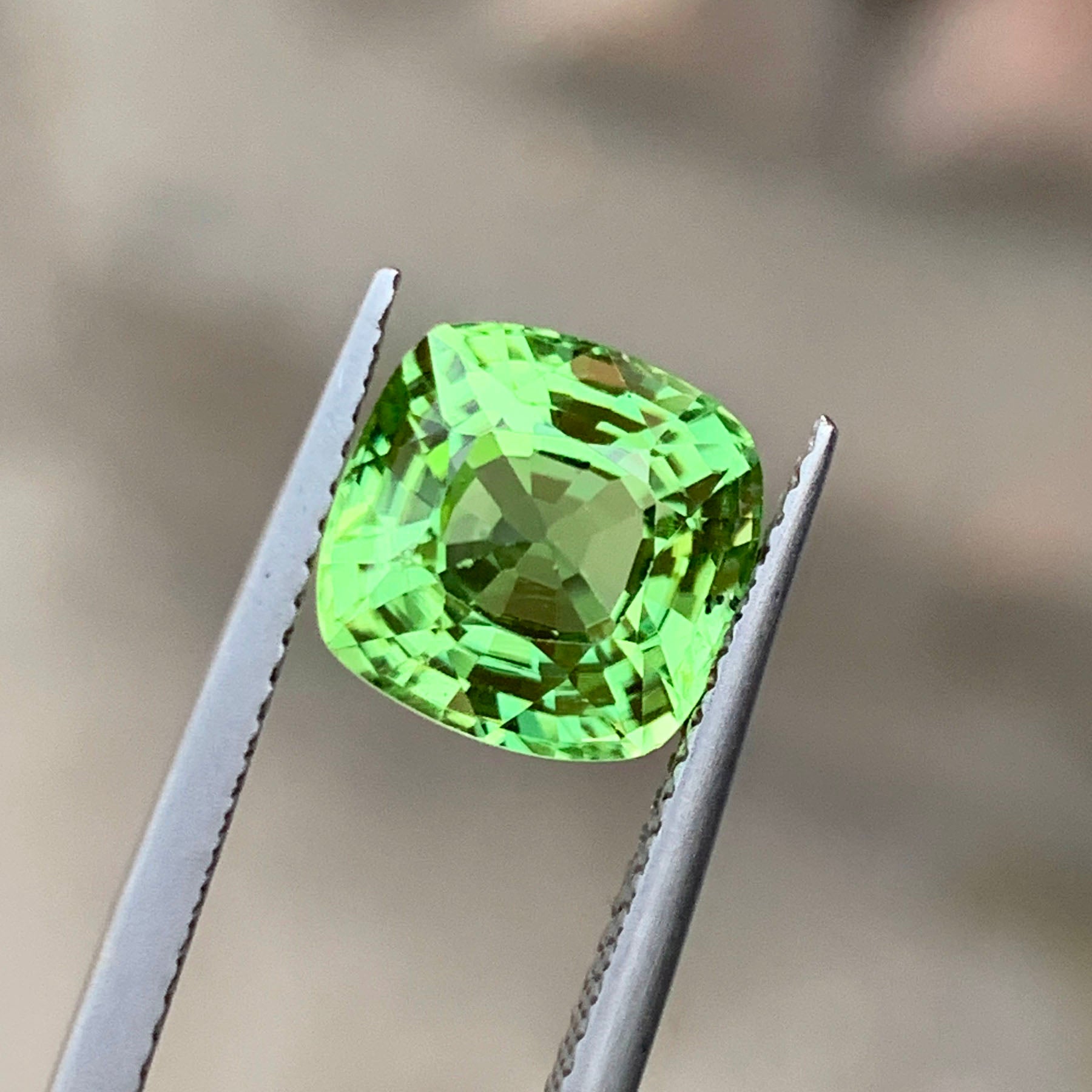 Peridot gemstone with scale reference for size
Cushion cut faceted crown detail on peridot
