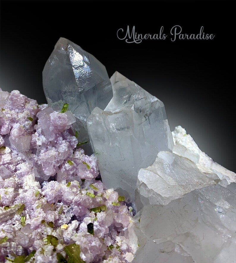 Pink lepidolite soft texture detail alongside green tourmaline
Clear quartz crystals perfectly shaped on tourmaline matrix