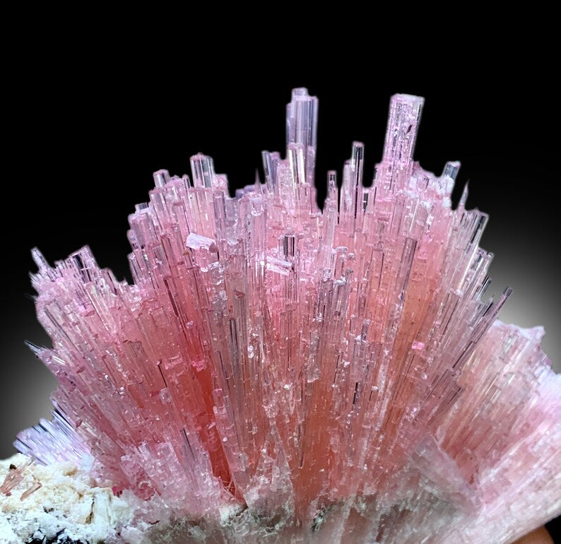 Rich pink color detail across tourmaline cluster
Raw tourmaline crystal cluster on natural matrix